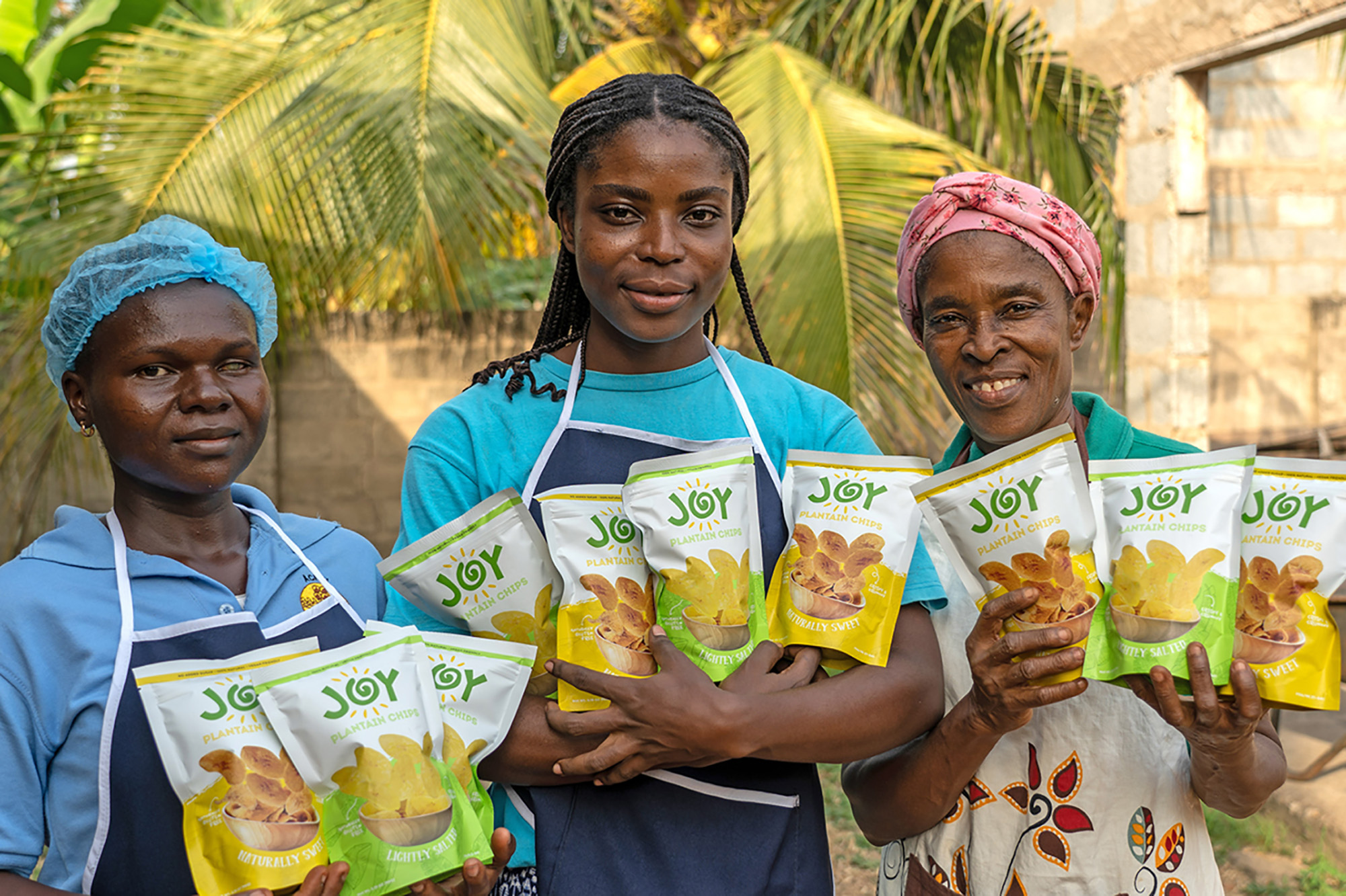 Three women holding bags of a healthy snack brand developed by one of them.