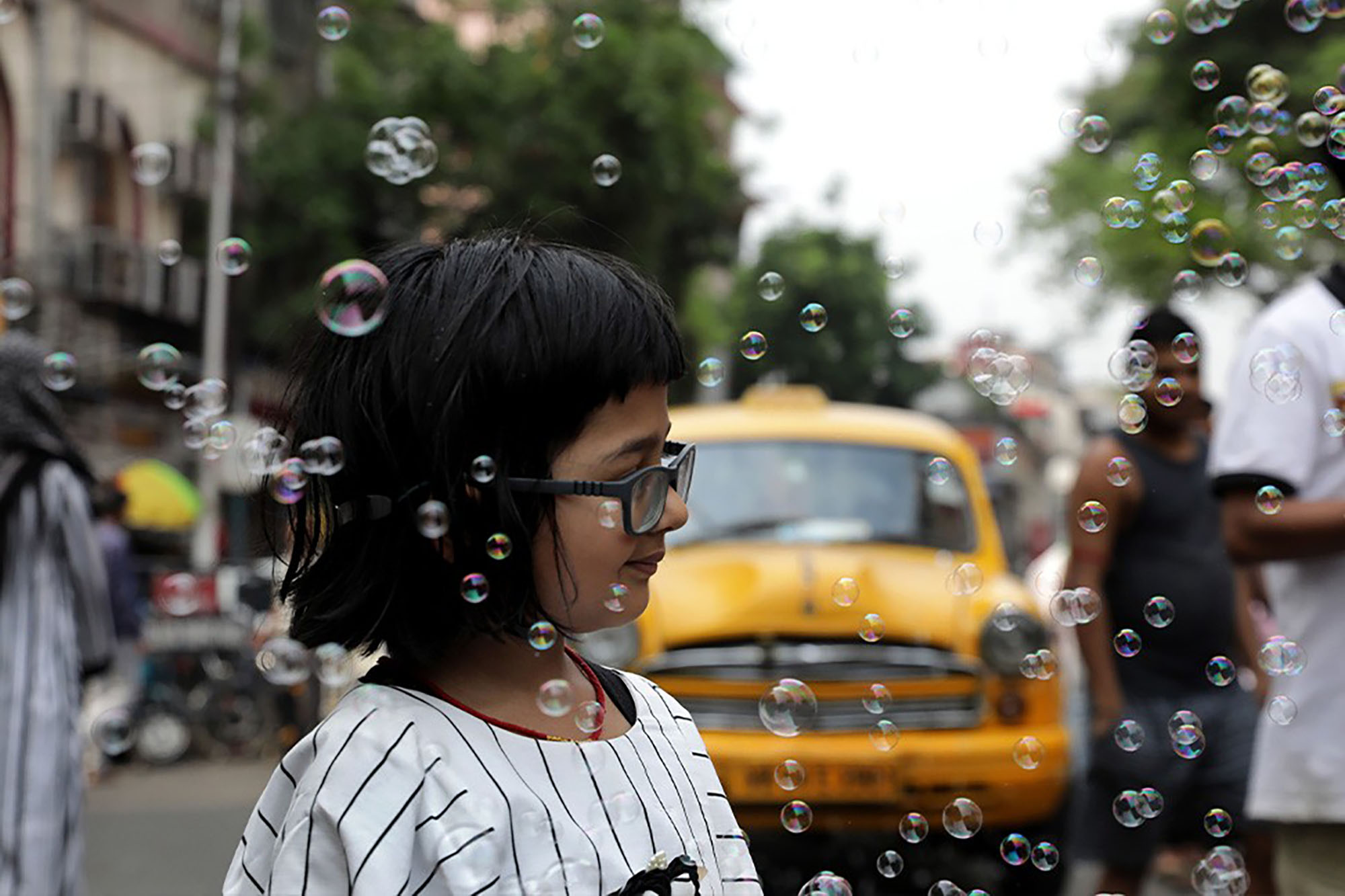 Image d'une fille marchant dans la rue, entourée de bulles.