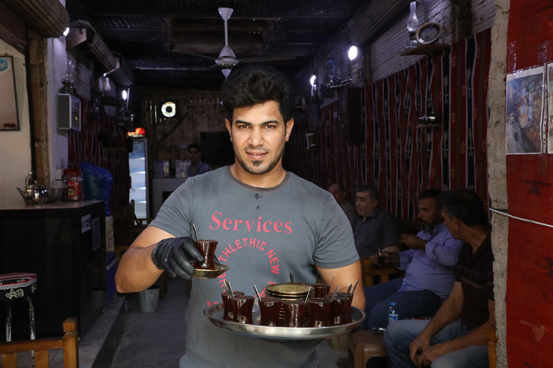 Un cafetier tient un plateau de café dans ses mains